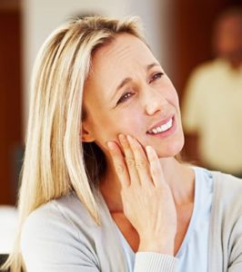blonde woman with dental pain at dental office.