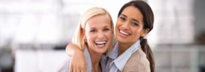 two young woman hugging and smiling