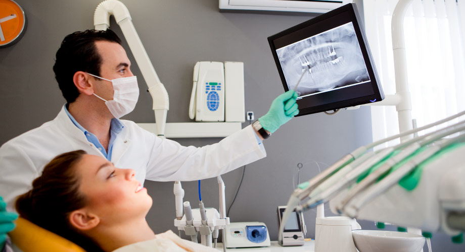 Dentist shows patient her dental X-rays