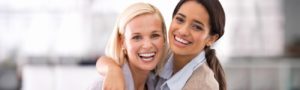 Women smiling after getting Invisalign clear alignment therapy