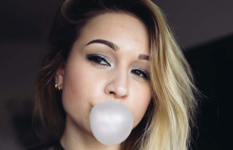 girl blowing a gum bubble