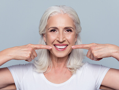 Woman Pointing At Her Mouth and Smiling