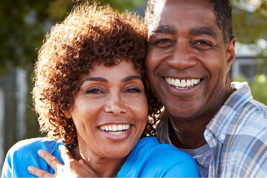 couple hug and smile to show off their professional teeth whitening