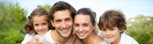 Family smiling outside after dental visit.