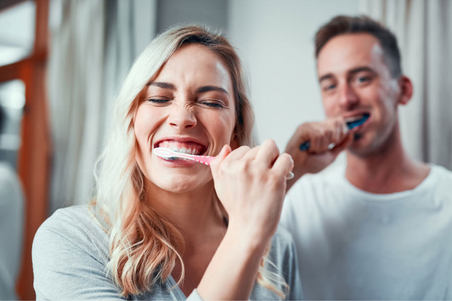 young couple brushing their teeth together