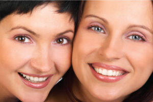 two women smile showing off their dental veneers