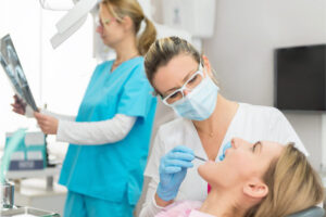 dental hygienist works on a female patient's teeth