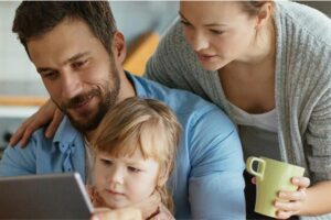 young family of three look at a laptop to review dental plans