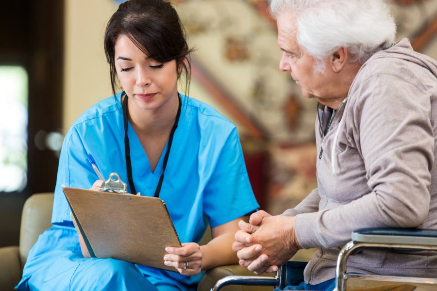 senior dental patient consults with dental worker on the in-house dental membership savings