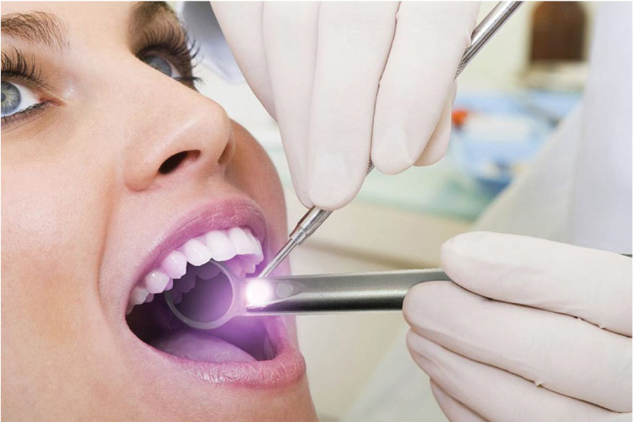 woman getting an oral cancer screening at the dentist