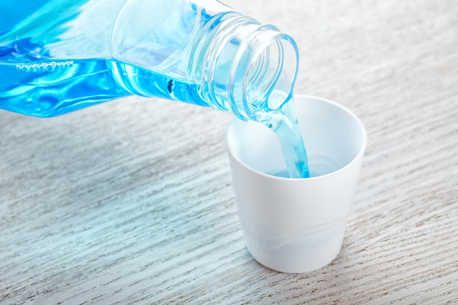 mouthwash being poured into a small cup