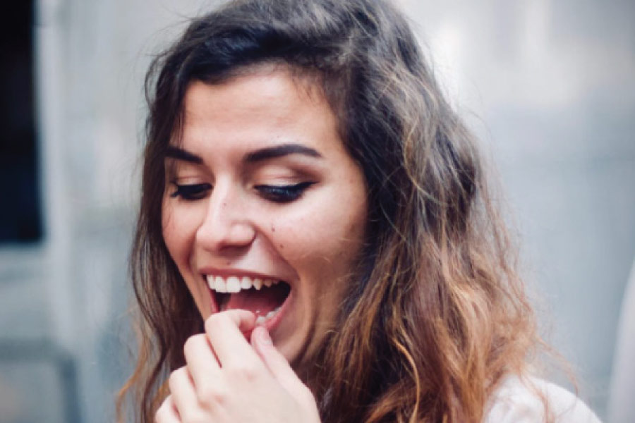 woman holds her tooth to check on a dental restoration