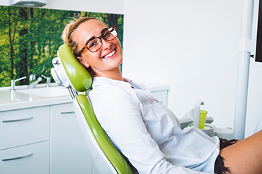 smiling young woman in dental chair