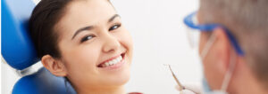 woman smiling and dentist holding dental tool